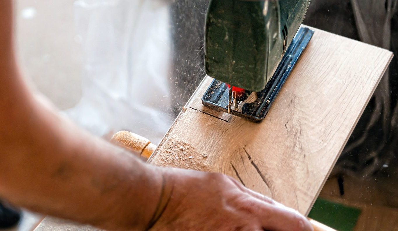 handyman Installing laminate flooring, carpenter cut parquet floor board with electric jigsaw